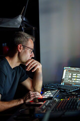 Video Director Managing Multiple Screens and Equipment in a Control Room During a Live Broadcast