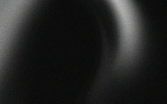 Abstract black and white background with a blurred light source creating a halo effect.