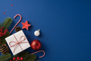 A beautifully wrapped Christmas gift surrounded by holiday decorations including pine branches,...