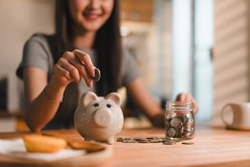 young woman is saving coins in piggy bank, showcasing financial responsibility and savings. scene...