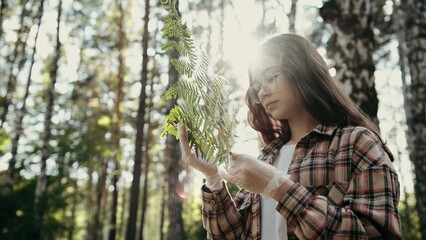 A Woman Enjoying the Beauty of Nature Surrounded by Fresh Herbs in a Peaceful Forest Setting. A...
