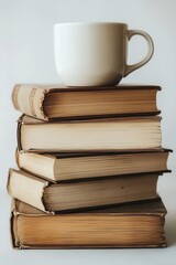 Naklejka premium A white mug rests atop a neatly arranged stack of vintage books. The serene setting features soft lighting, creating a warm and inviting atmosphere perfect for reading and enjoying a hot beverage.