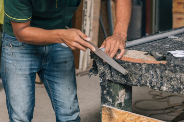 Unrecognizable person polishing the edge of a pipe
