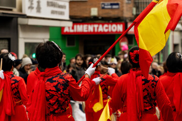 Chinese women playing drums and holding the Spanish flag on Lunar New Year parade