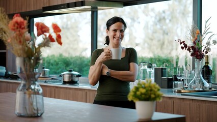 Happy old grandmother confidently standing pose while look at camera for good event or anniversary in kitchen. Cheerful senior enjoy retirement life with beautiful kitchenware and house. Divergence.