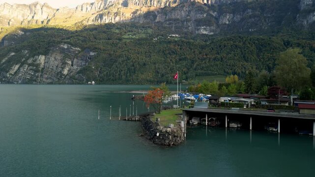 boat pier with switzerland flag. dawn sunny day. Walensee, Schweiz