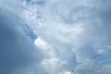 Clouds billow across the vast expanse of the azure sky