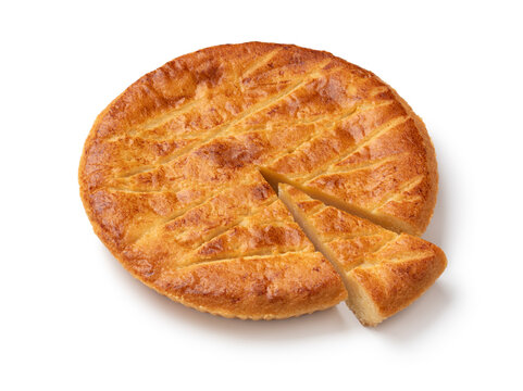 Single traditional fresh baked Dutch Boterkoek, butter cake and a piece isolated on white background close up