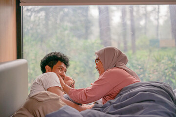 A couple is having a romantic conversation in a cabin with wide glass windows with a view of the forest