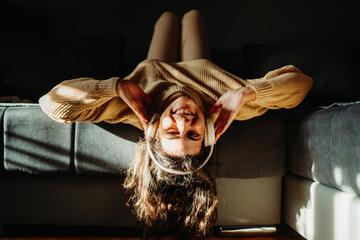 Young caucasian woman enjoying music on wireless headphones at home	
