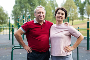 Elderly man and woman posing in open-air sports bars complex