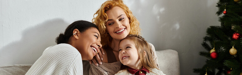 A beautiful family shares laughter and joy together in their cozy living room during the holidays.