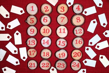 Wooden decorative 1 to 24 log button designs against a red stitch background, surrounded by plain wooden tags with heart symbols.