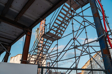 A minimalist urban scene showcasing a construction site with a towering crane. Highlights the intersection of infrastructure, development, and modern architecture under a clear sky.