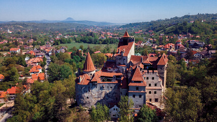 Bran Castle overlooking the lush landscape and village in Transylvania on a clear sunny day