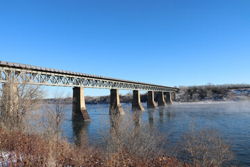 Landscape Winter Scene Of The CPR Rail Bridge Crossing The South Saskatchewan River In Saskatoon,...