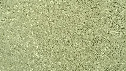 A wall with a green paint that has a rough texture