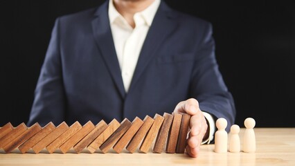 Risk, Business Risk Management, Economic, Financial Crisis Concept. Business man stop wooden block domino effect to safe, protect family, home from economic financial crisis. Concept Risk, Insurance.