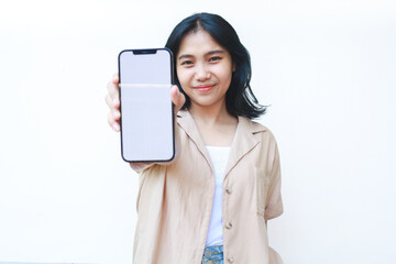 happy asian woman showing smartphone white screen wearing brown casual clothes isolated on white background