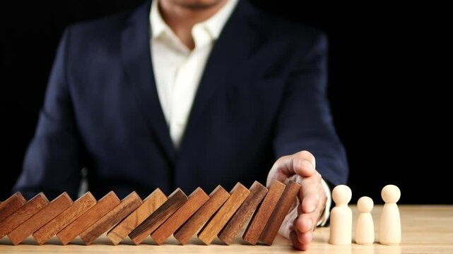 Risk, Business Risk Management, Economic, Financial Crisis Concept. Business man stop wooden block domino effect to safe, protect family, home from crisis. Concept Risk, Insurance. Slow Motion