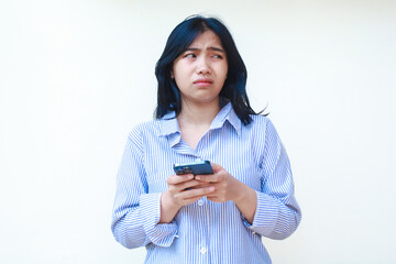 sad asian woman holding smartphone is crying disappointed wearing striped shirt isolated on white background