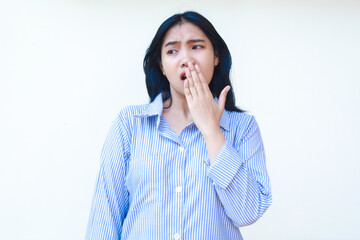 shocked asian woman covering her mouth wide open wearing striped shirt isolated on white background