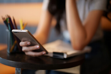 Asian teenage student woman using smartphone to surfing social media and entertainment for...