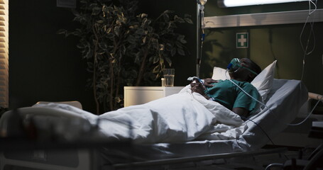 Nervous African girl lies in the hospital under an oxygen mask.