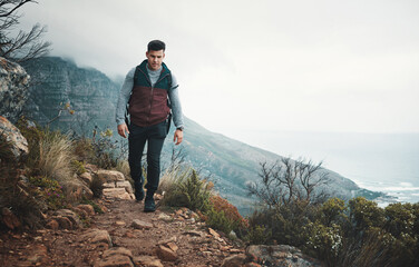 Obraz premium Hiking, trail and travel with man on mountain for explore, walking and adventure. Challenge, wellness and holiday with person and trekking in nature path for backpacking, fitness and vacation