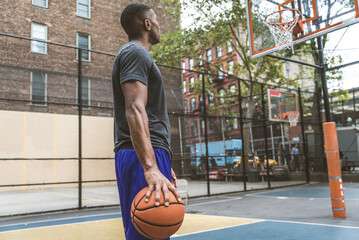 Black sportive basketball player playing basketball on a court in New York City
