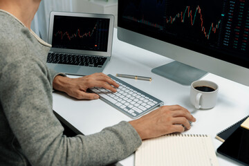 Cropped business trader using computer to search highest profit value of dynamic increased stock market graph on working desk, analyzing exchange rate on pc monitor screen at modern office. Pecuniary.