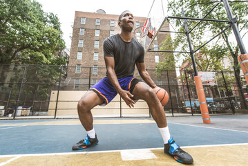 Black sportive basketball player playing basketball on a court in New York City