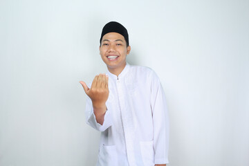 smiling muslim asian man show inviting gesture with looking at camera isolated on white background