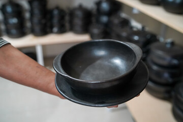 Woman's hand holding earthenware soup dish
