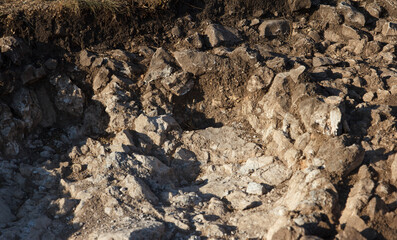 Rocky bottom of an archaeological pit dug on a hillside in search of historical artifacts