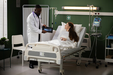 Doctor and patient review the progress of the prescribed treatment plan by examining leg X-rays on a tablet, facilitating an ongoing dialogue about the effectiveness of the interventions.