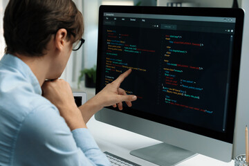 IT developer selecting by point on coding online software development information on pc comparing...