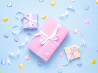 Pastel gift boxes with ribbons and hearts on a blue background