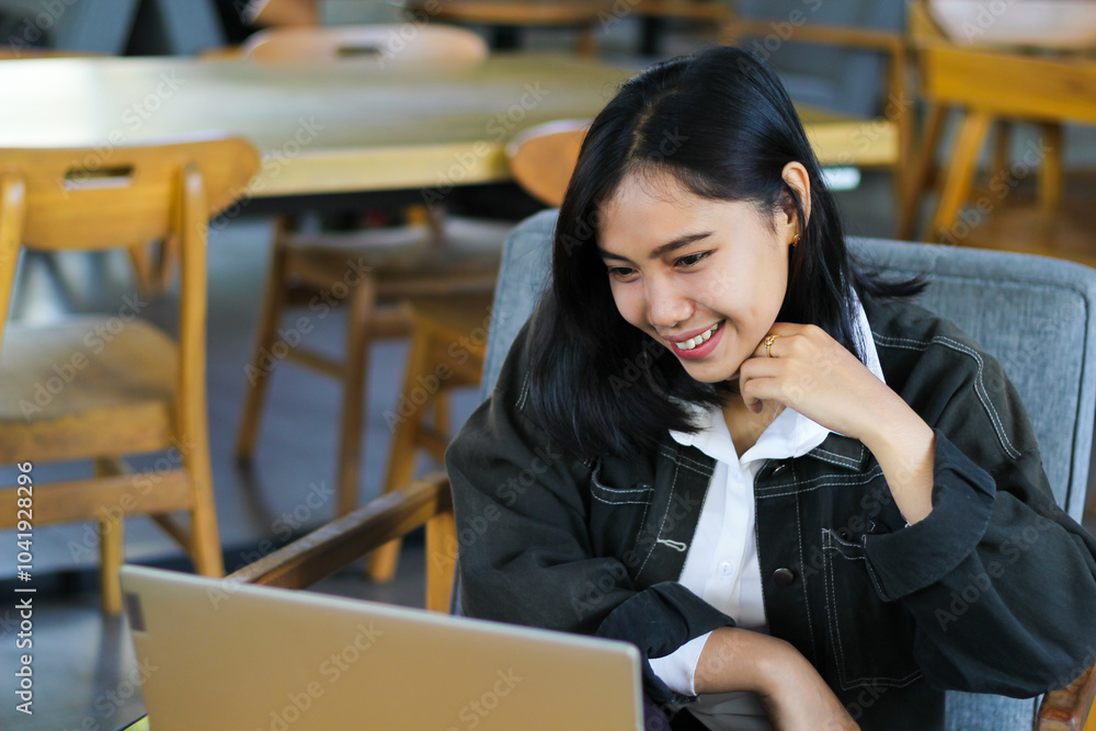 Wall mural cheerful asian woman using laptop to have online meeting video conference in indoor cafe