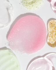 Composition of various cosmetic scrub, creams and serum smear on white background. Beauty texture. Sample of a cosmetic product