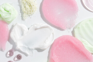 Composition of various cosmetic scrub, creams and serum smear on white background. Beauty texture. Sample of a cosmetic product