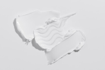White beauty cream smear smudge on white background. Cosmetic skincare product texture. Face cream, body lotion swipe swatch