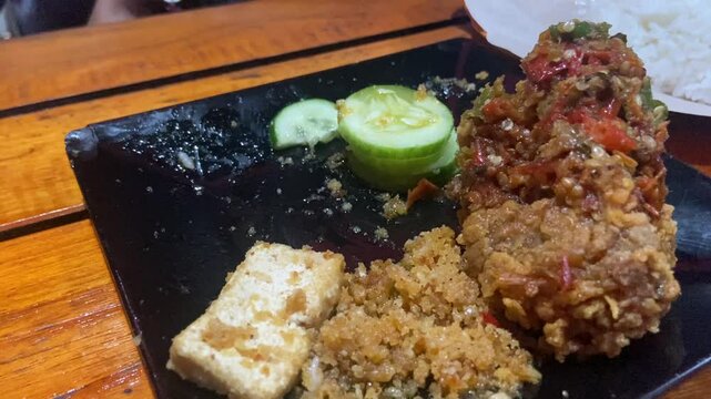 Eating "Ayam Geprek" Indonesian Traditional Food with chili Suce at the restaurant