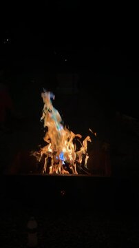 A fire is burning in a fire pit. The fire is orange and yellow.