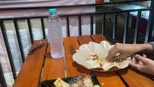 Eating "Ayam Geprek" Indonesian Traditional Food with chili Suce at the restaurant