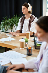 Obraz premium A young plus size woman works intently while her male friend concentrates nearby in a cafe.