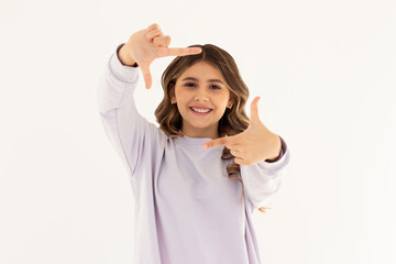 Portrait of young beautiful brunette woman cheerfuly smiling making a camera frame with fingers....