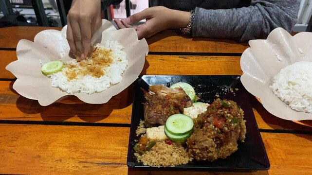 Eating "Ayam Geprek" Indonesian Traditional Food with chili Suce at the restaurant