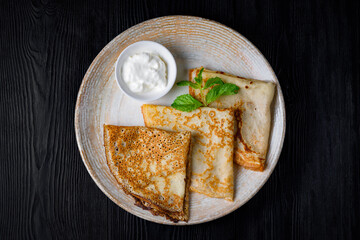 breakfast, pancakes with sour cream. on a black wooden background