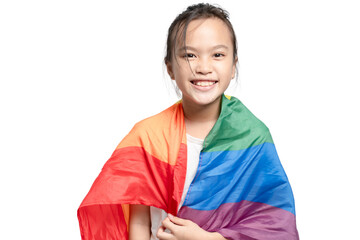 A young girl is wearing a rainbow flag and smiling